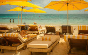 Puerto Morelos beach print featuring yellow umbrellas, striped loungers, and turquoise Caribbean water in Mexico.