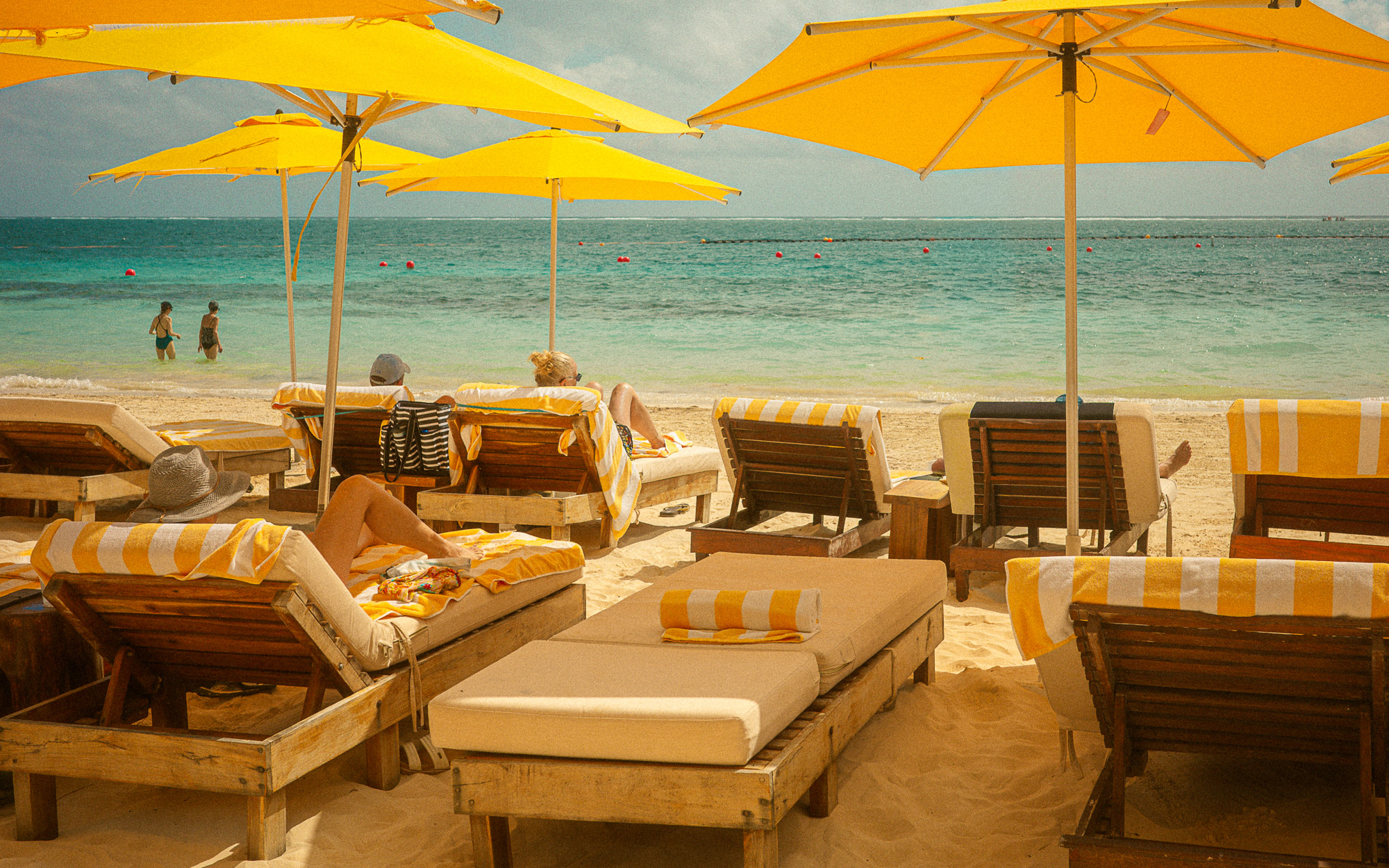 Puerto Morelos beach print featuring yellow umbrellas, striped loungers, and turquoise Caribbean water in Mexico.